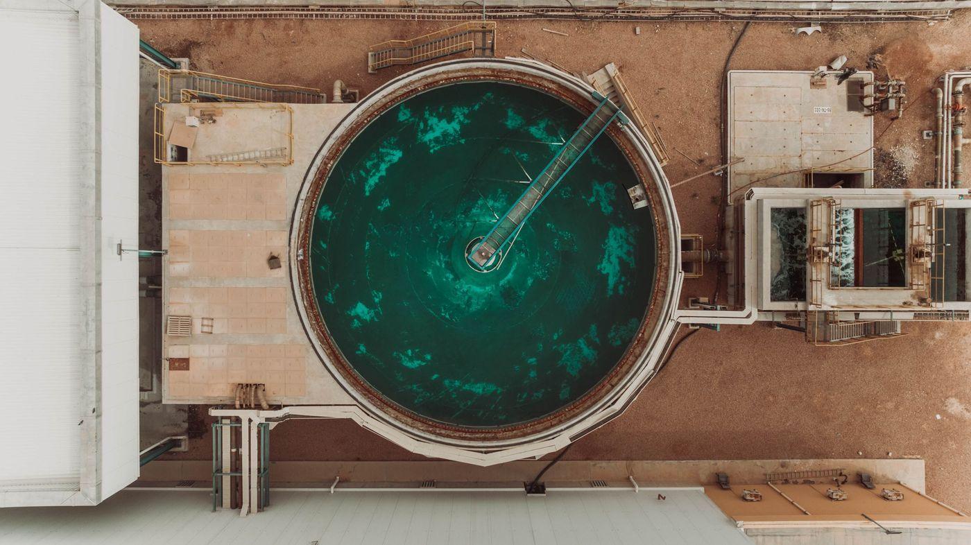Aerial view of a circular settling tank at a water treatment and desalination facility